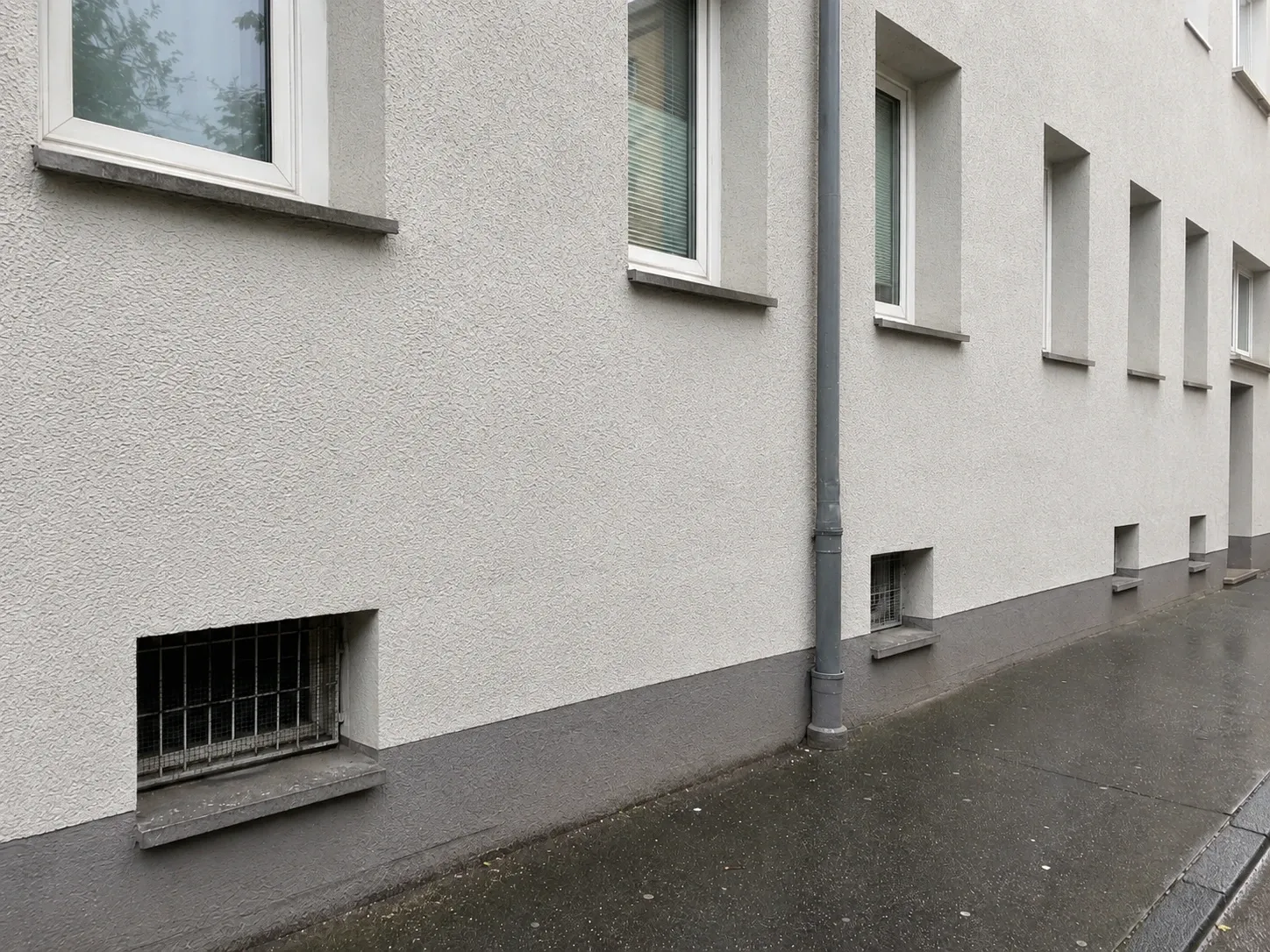 Dieselbe Fassade nach der Graffitientfernung, sauberer Putz ohne Farbreste